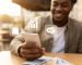 Main tenant un smartphone, symbole des 3 business en ligne à lancer avec un téléphone